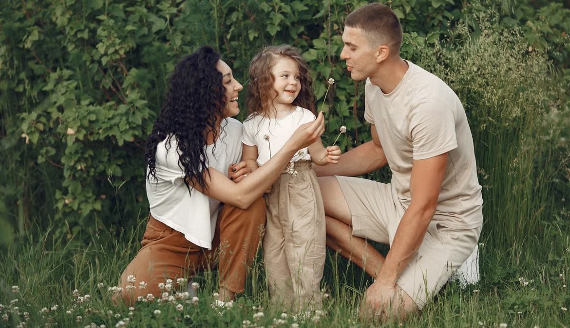 A joyful family enjoying time together in a lush green meadow, capturing love and bonding.